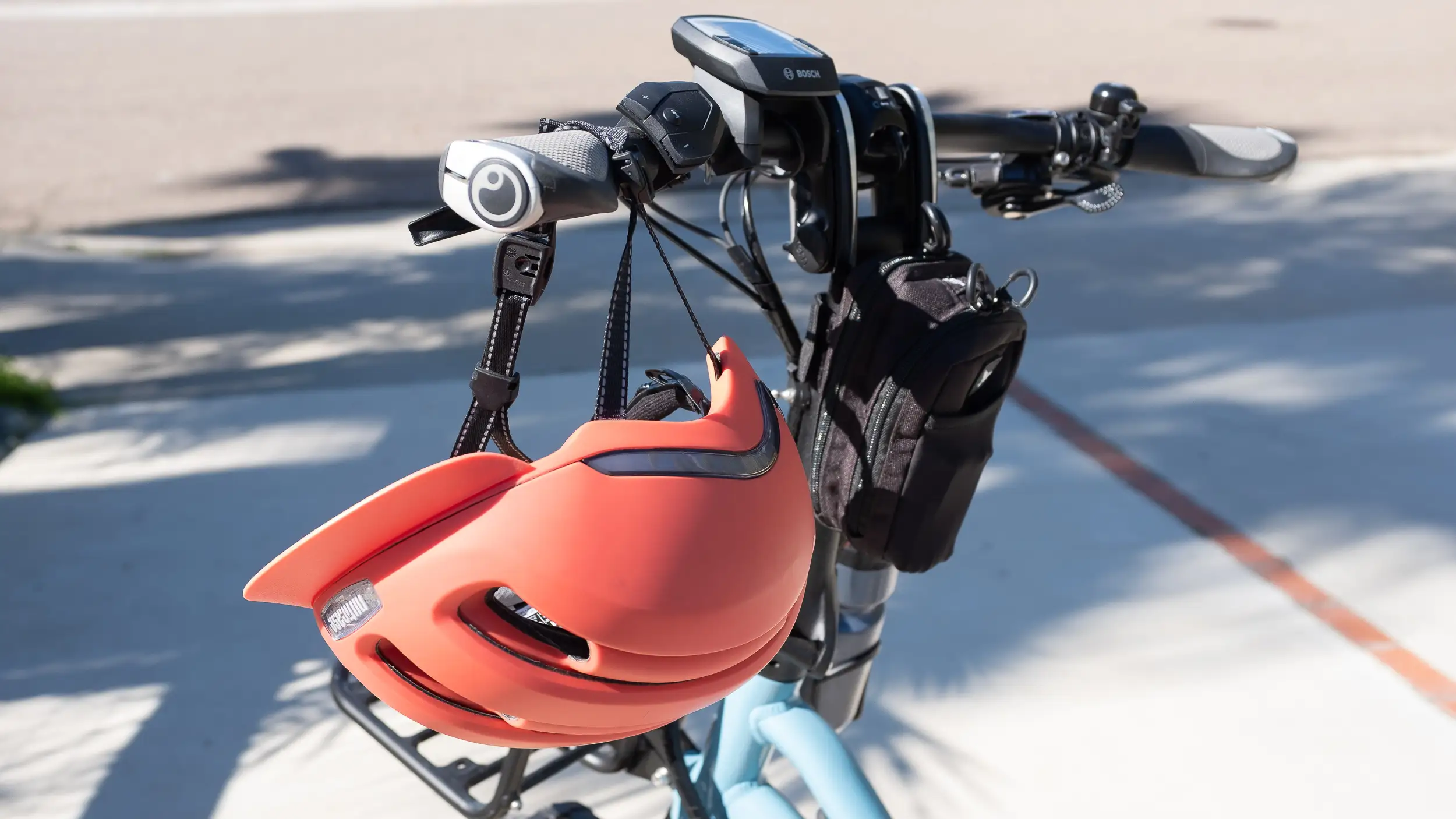 A bike helmet hangs on the handlebars of a Tern HSD e-bike